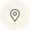 A simple map pin icon inside a beige circle.