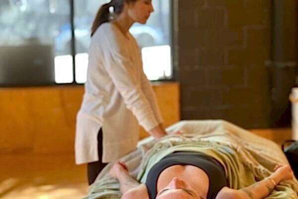 A therapist performing a massage on a client lying on a table.