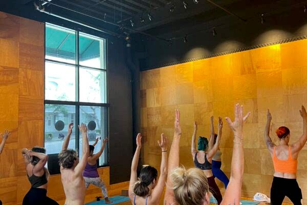 Group yoga class practicing poses in a warm, cozy studio.
